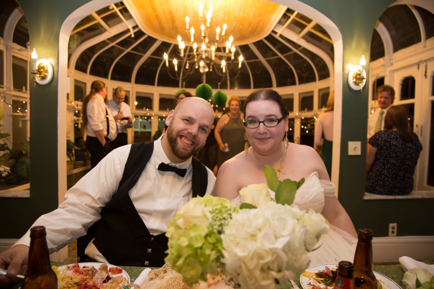 Weddings at Tarrywile shaina and zach at head table with conservatory in the background
