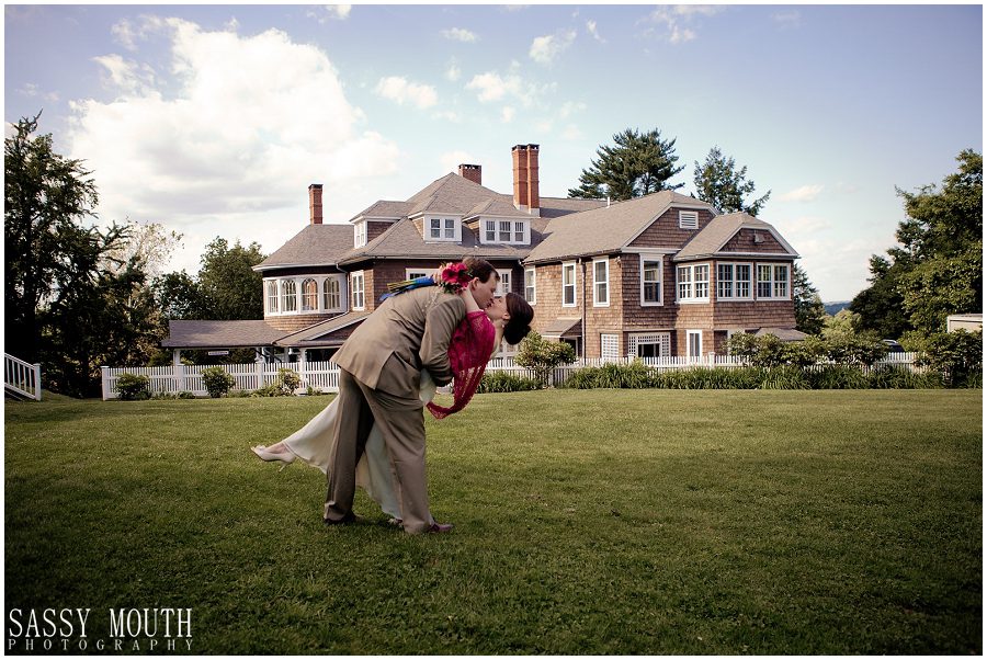 Weddings at Tarrywile groom dipping bride for kiss in front of mansion
