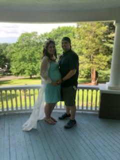 Events at Tarrywile Mansion pregnant mom and dad holding each other on the veranda