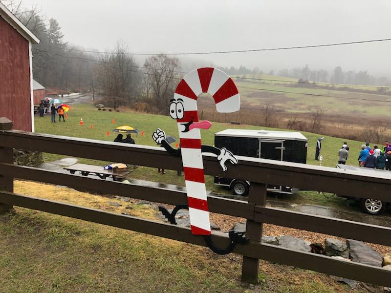 Tarrywile Fundraisers fence by red barn with funning candy cane poster