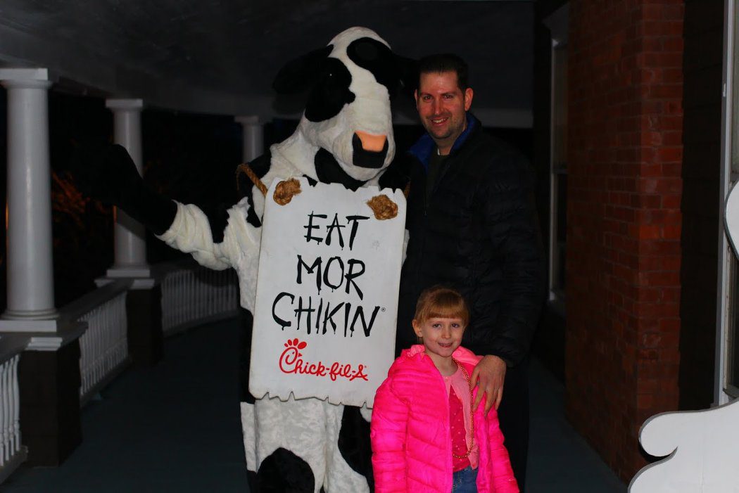 Events at Tarrywile Mansion dad, daughter, with cow that says eat more chicken